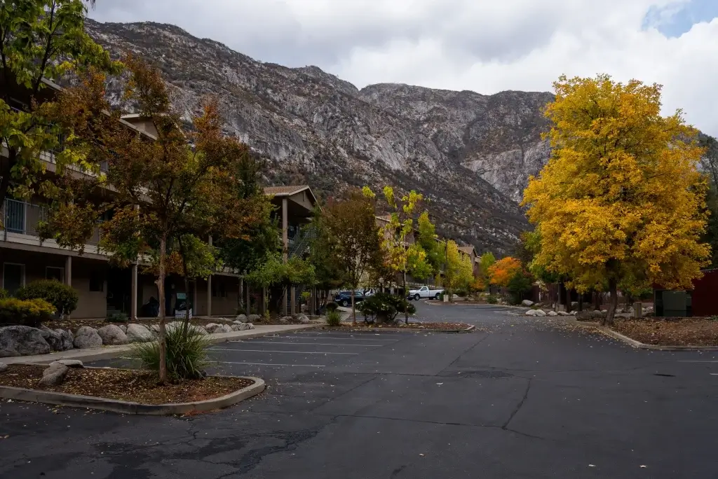 Exterior shot of Yosemite view Lodge with changing color of trees and mountains in background